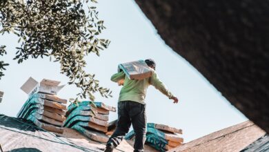 construction worker carrying heavy shingles