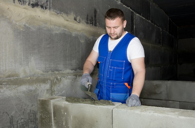 person building the wall from aac