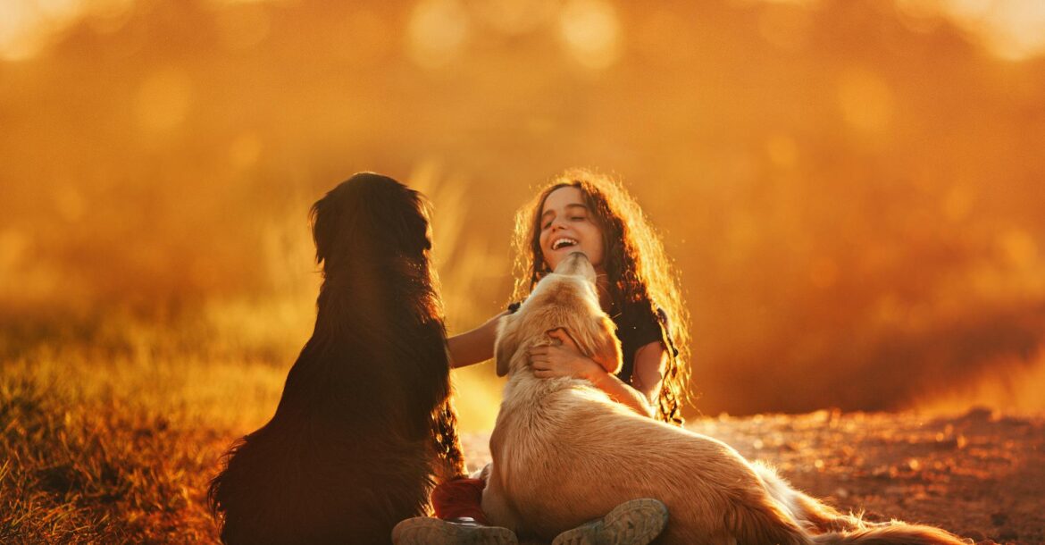 happy-girl-playing-with-dogs-on-ground